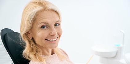 a patient smiling after receiving her new dental implants
