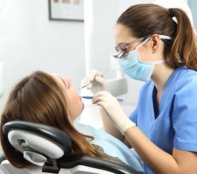 dental hygienist cleaning a patient’s mouth