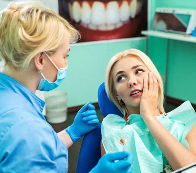 Woman with dental emergency in Edmond talks to her dentist