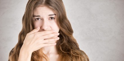 Woman with lost filling covering  mouth