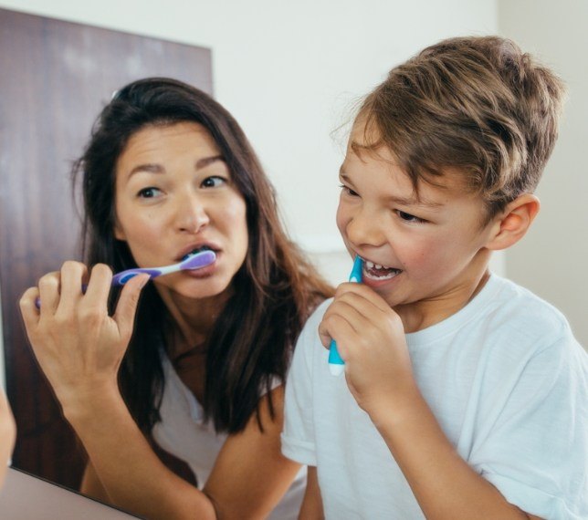 Mother and son brushing teeth to prevent dental emergencies