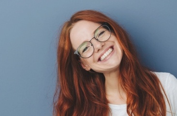 Smiling woman with red hair and glasses