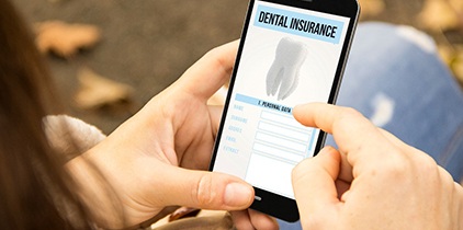 A woman looking at a dental insurance form on her phone