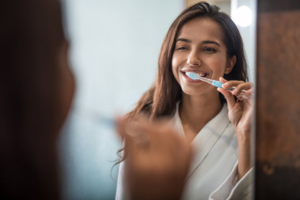 a woman brushing her teeth in her bathroom